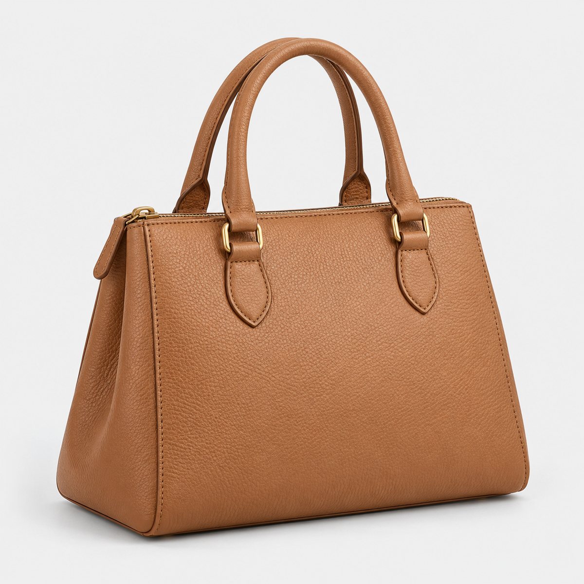 A structured tan leather handbag with brass hardware on a plain light grey background