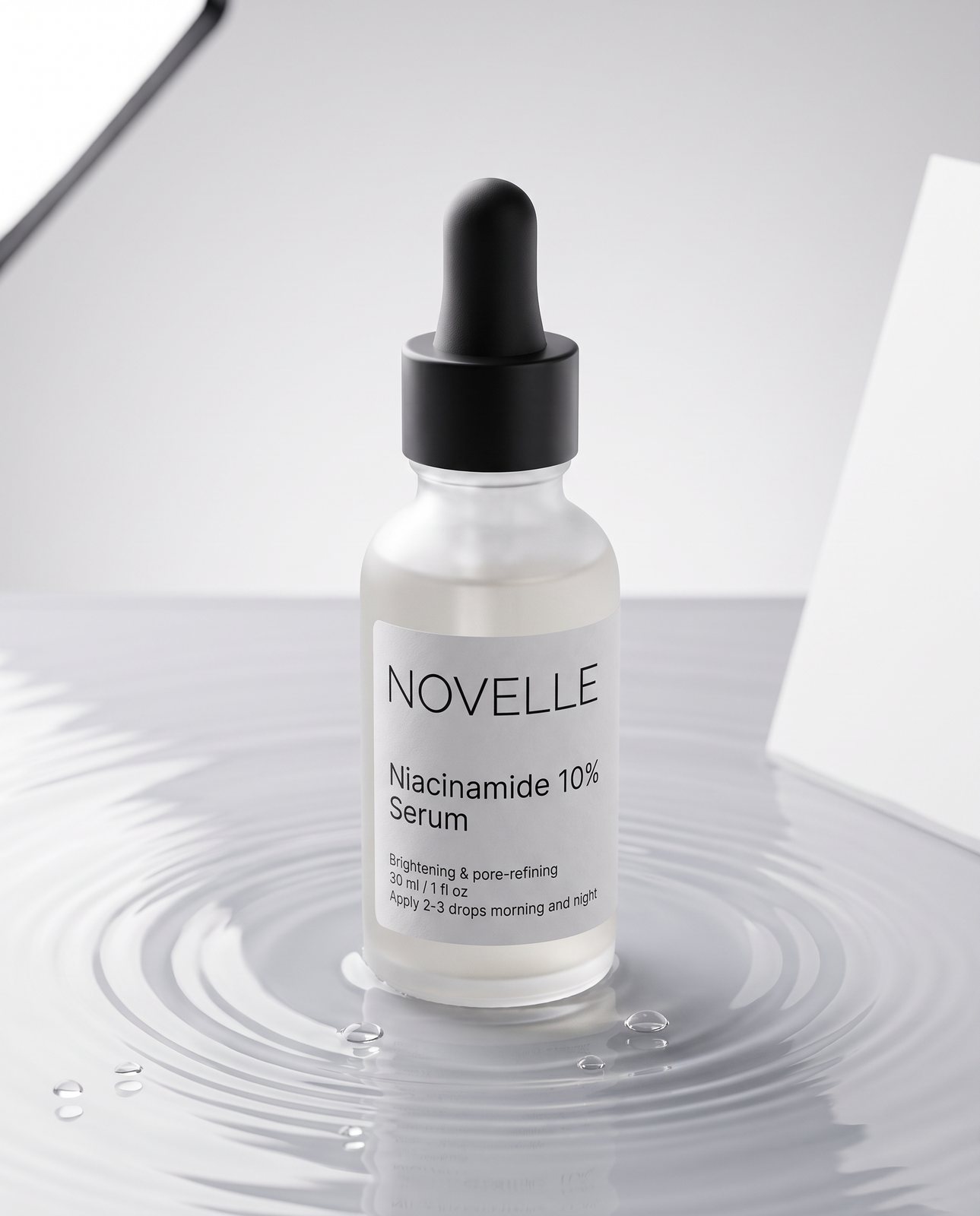 The same frosted glass serum bottle with its black dropper standing in rippling water, its small label text sharp