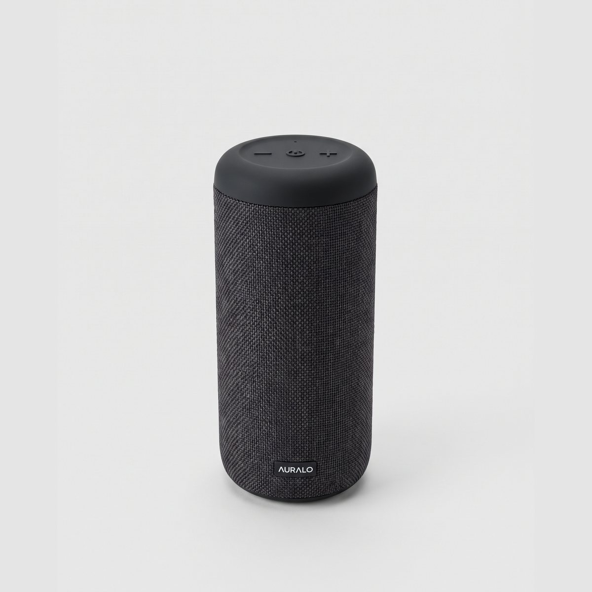 The original photo: a charcoal fabric portable speaker with a matte black top and a small white AURALO wordmark on a plain light grey background
